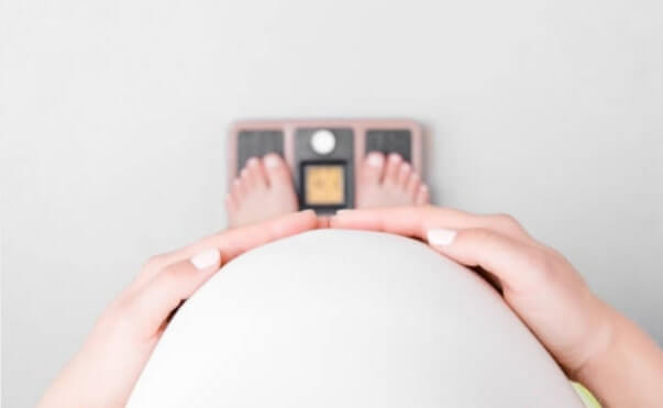 Pregnant woman measuring weight